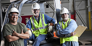 Workers standing near a truck in a workplace.
