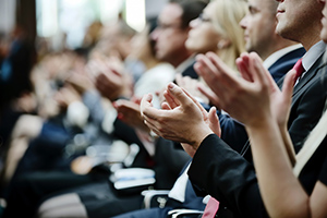 People clapping at an event.