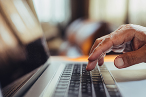 Hand typing on a computer keyboard.